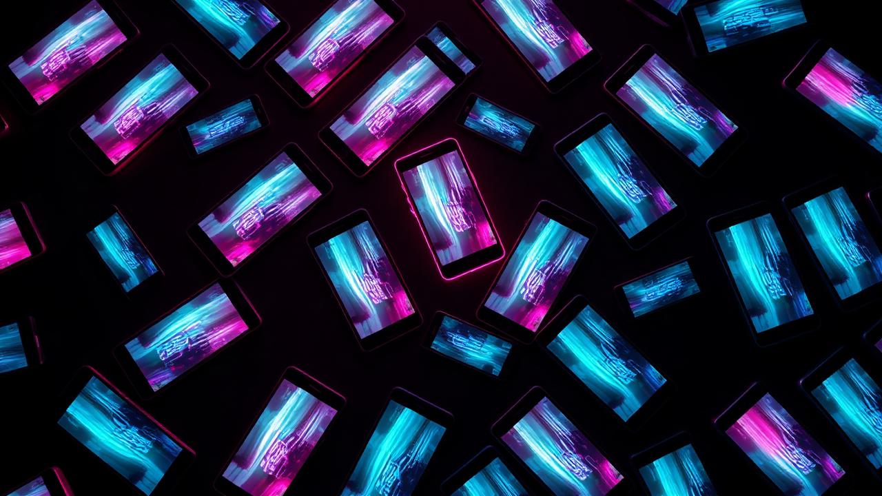 Vários celulares espalhados em fundo escuro com luzes neon